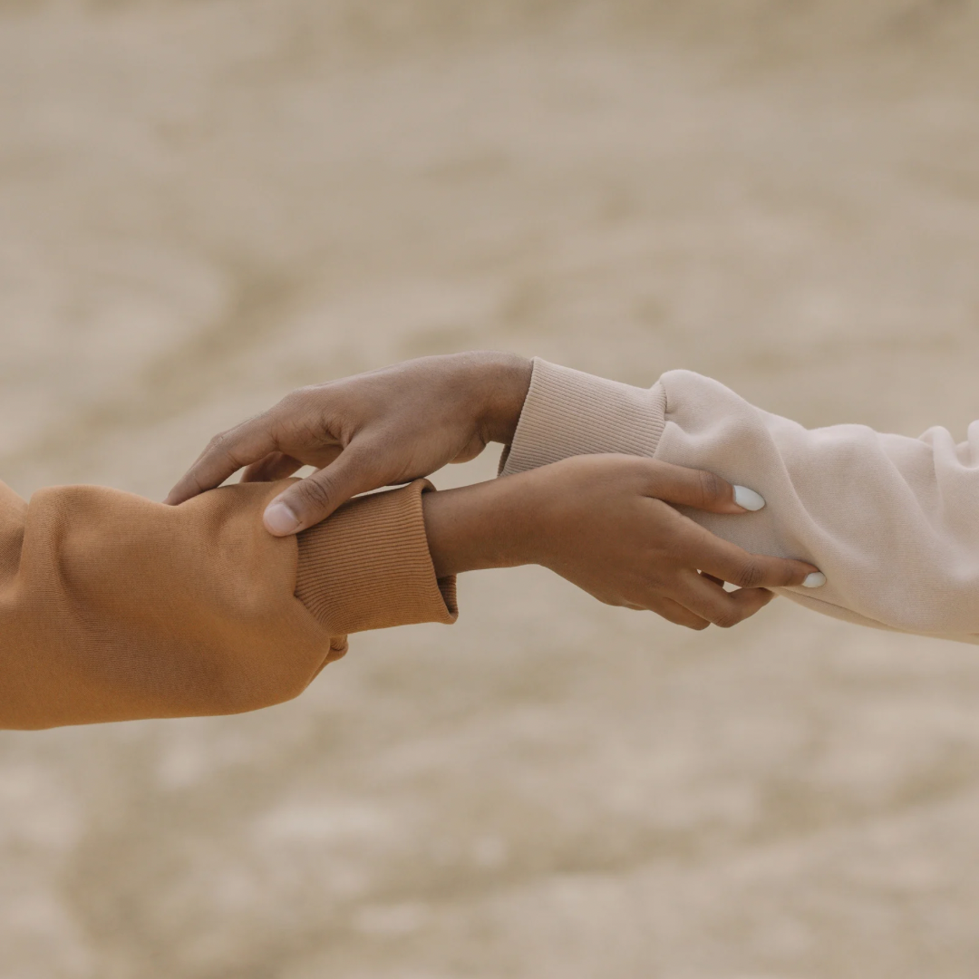 Two women's arms reaching out and holding each other - YOU Psychiatry Clinic